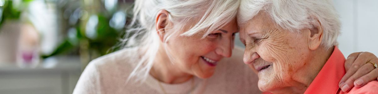 Middle aged daughter embracing elderly mother