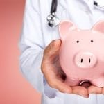 Doctor holding a piggy bank in both hands – Financial advice for healthcare professionals to secure financial stability and future investments.