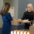 Receptionist handing financial documents to a client – financial advice and personalised client services
