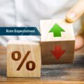Hand holding percentage blocks with arrows – Financial advice on interest rate expectations and market trends