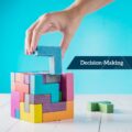 Hand assembling puzzle blocks – Financial advice on decision-making for personal finances and investments